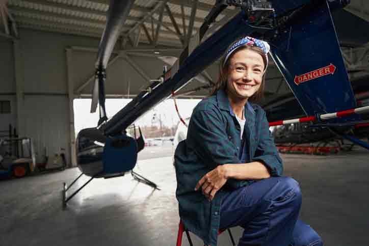 Woman sitting in back of helicopter as an airframe technician